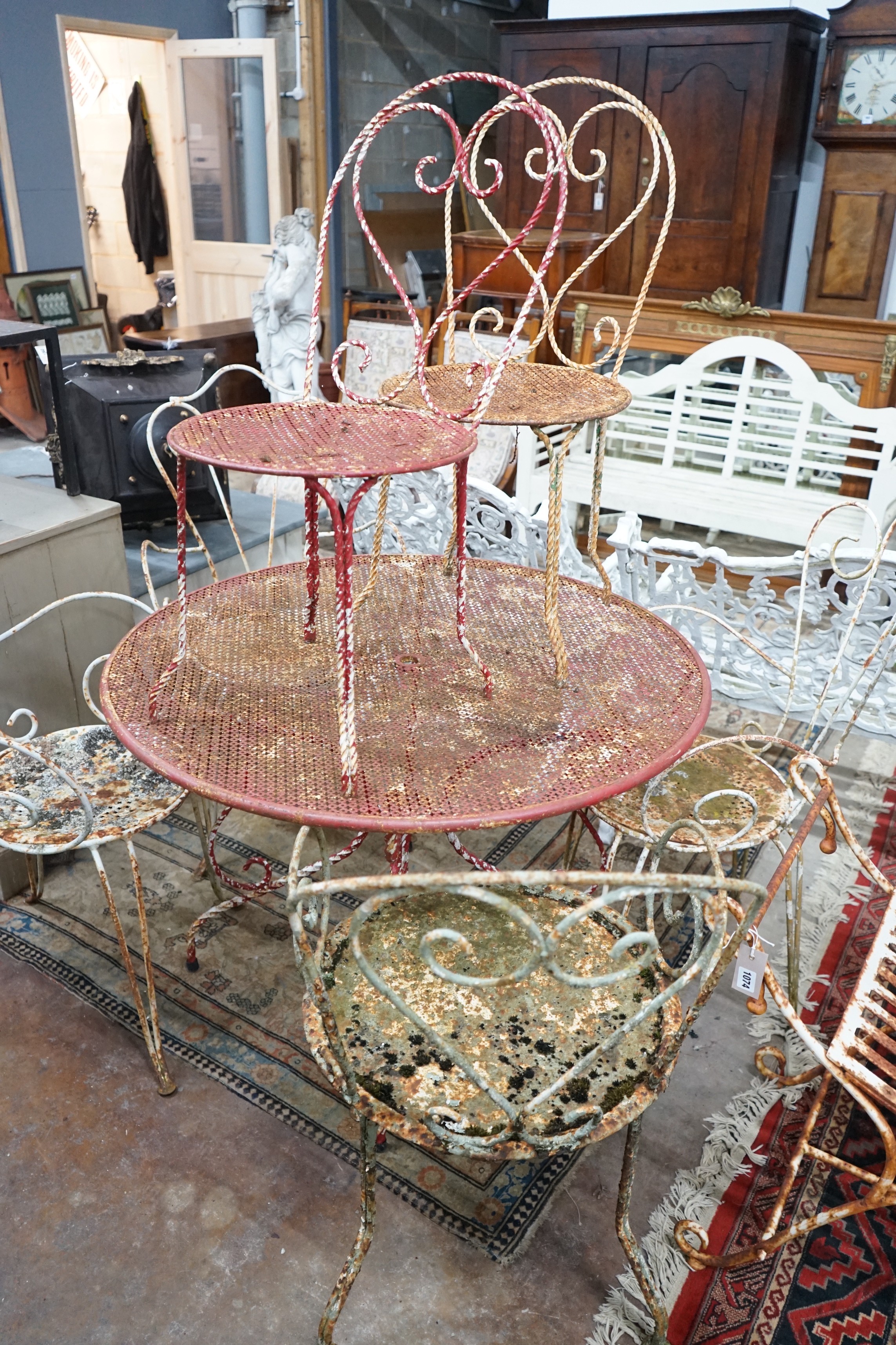 A vintage painted circular wrought iron garden table, diameter 99cm, height 70cm and six chairs, (three plus three)
